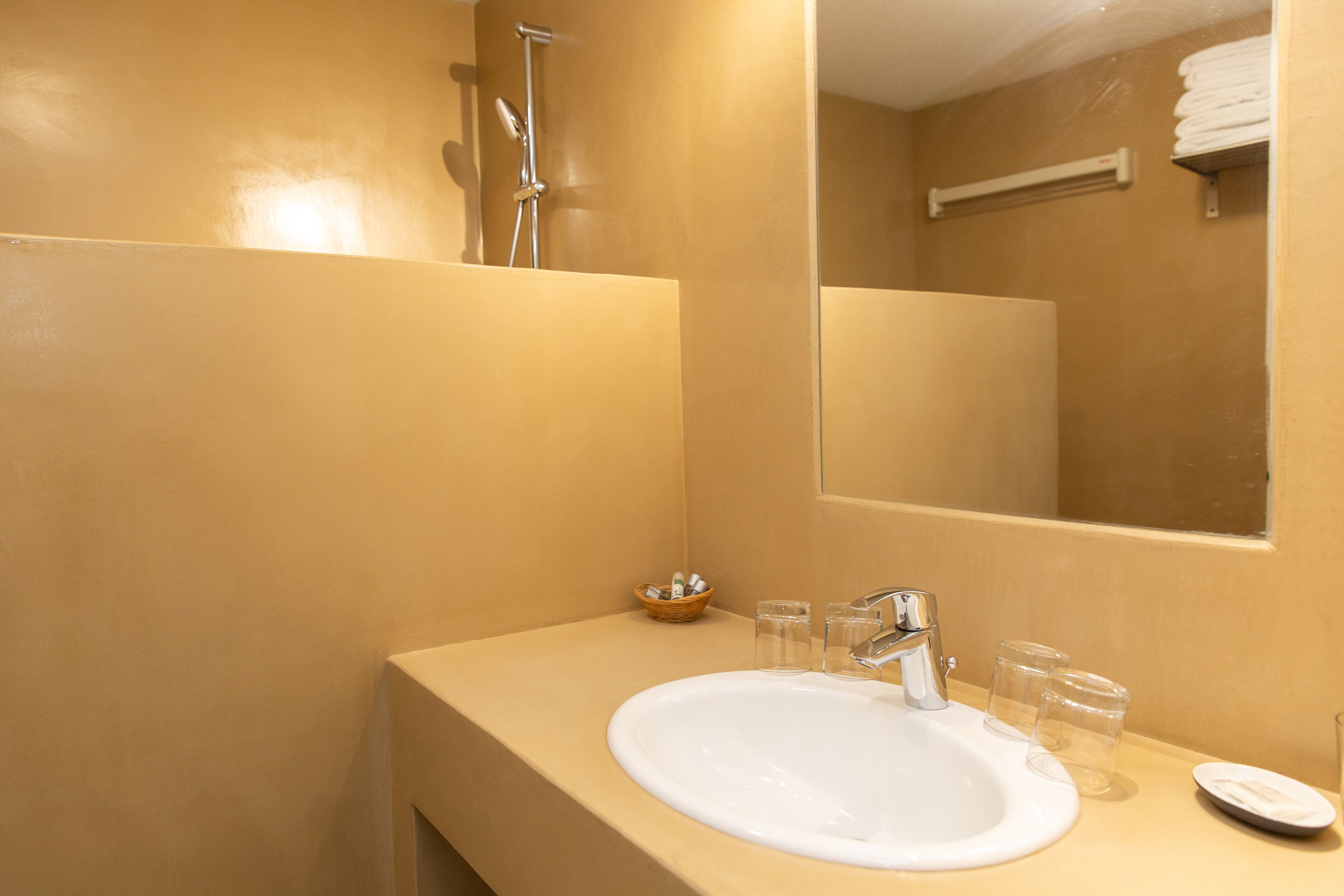 A bathroom with a white sink, a mirror, and a towel rack.