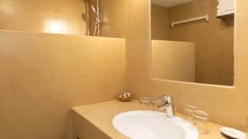 A bathroom with a white sink, a mirror, and a towel rack.