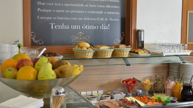 A breakfast buffet with fruits, pastries, and beverages. - Pousada Stillo Gramado (Gramado)