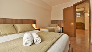 A hotel room with two beds, a wooden headboard, and a wooden floor. - Pousada Stillo Gramado (Gramado)
