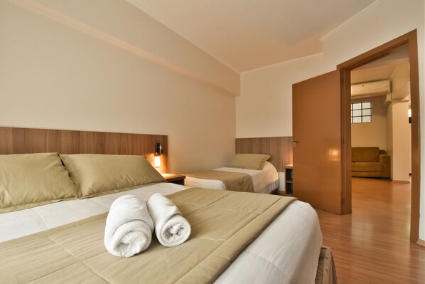 A hotel room with two beds, a wooden headboard, and a wooden floor. - Pousada Stillo Gramado (Gramado)