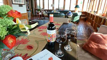 Una mesa con una botella de vino, dos copas de vino y un arreglo floral.