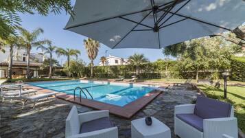 Utomhuspool, parasoller och solstolar