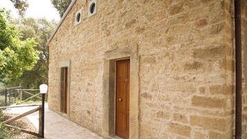 Un edificio de piedra con dos puertas de madera y un pequeño ventanal.