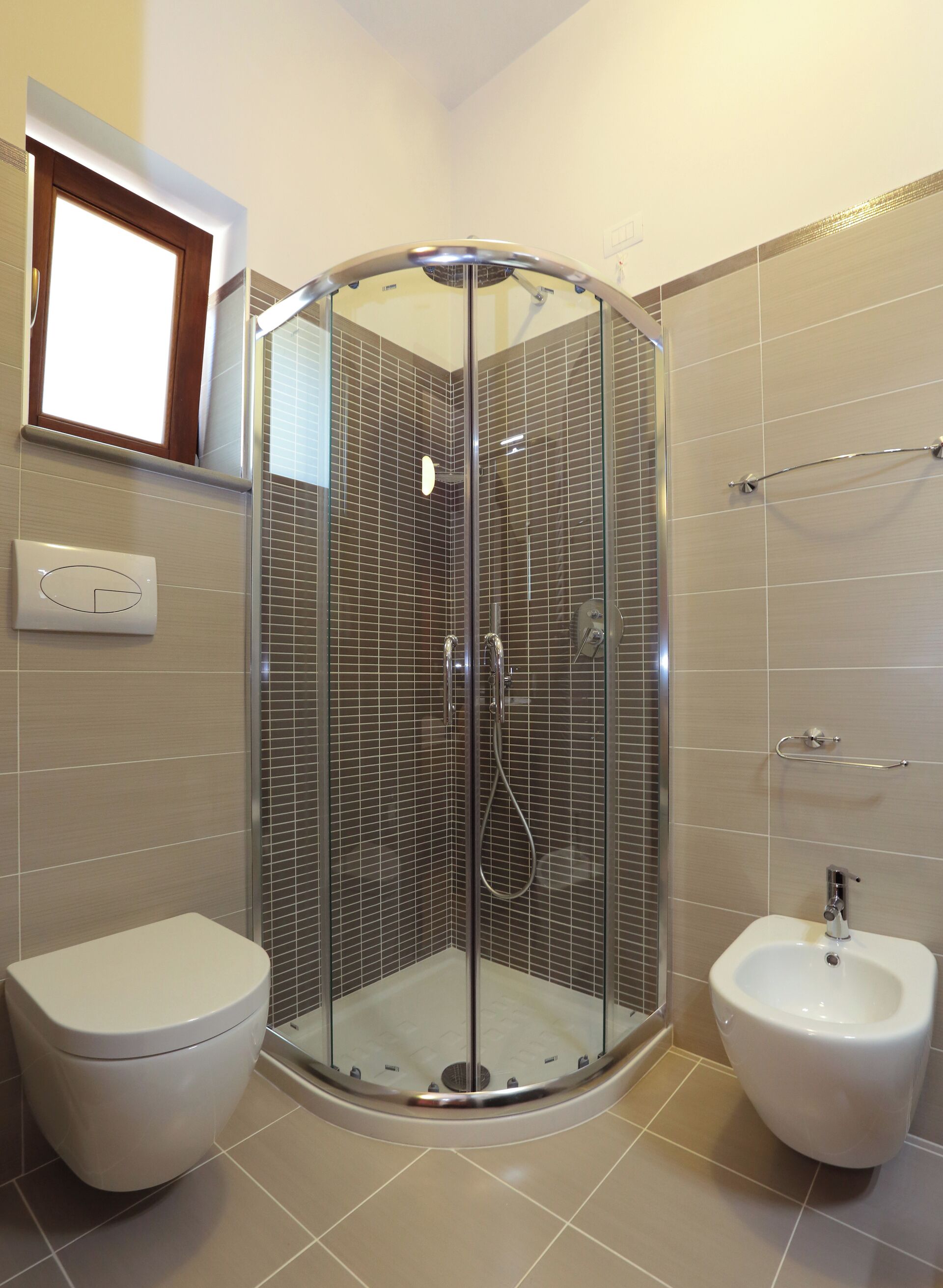 Un baño moderno con ducha de vidrio, inodoro y bidé.