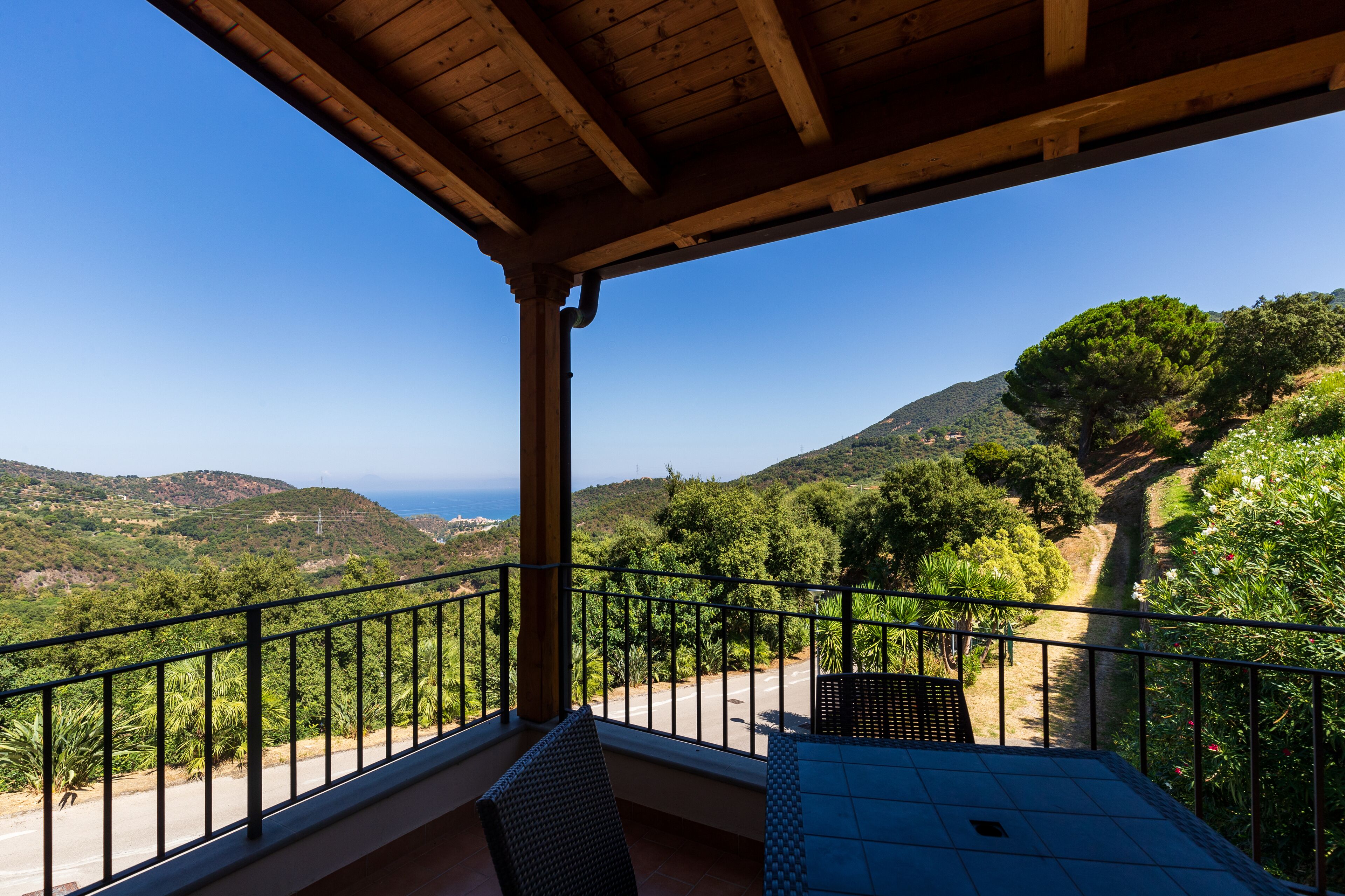Un balcón con vistas a un paisaje montañoso y al mar.