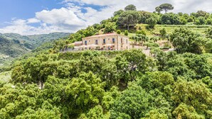 A stone building with a red roof, surrounded by lush greenery and trees, on a hillside. - Villa Ginevra Resort Agrituristico (Ficarra)