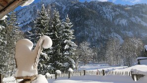 A snow-covered landscape with a wooden structure, snow-covered trees, and a mountain in the background. - Chalets&Apartments beim Waicher (Ruhpolding)