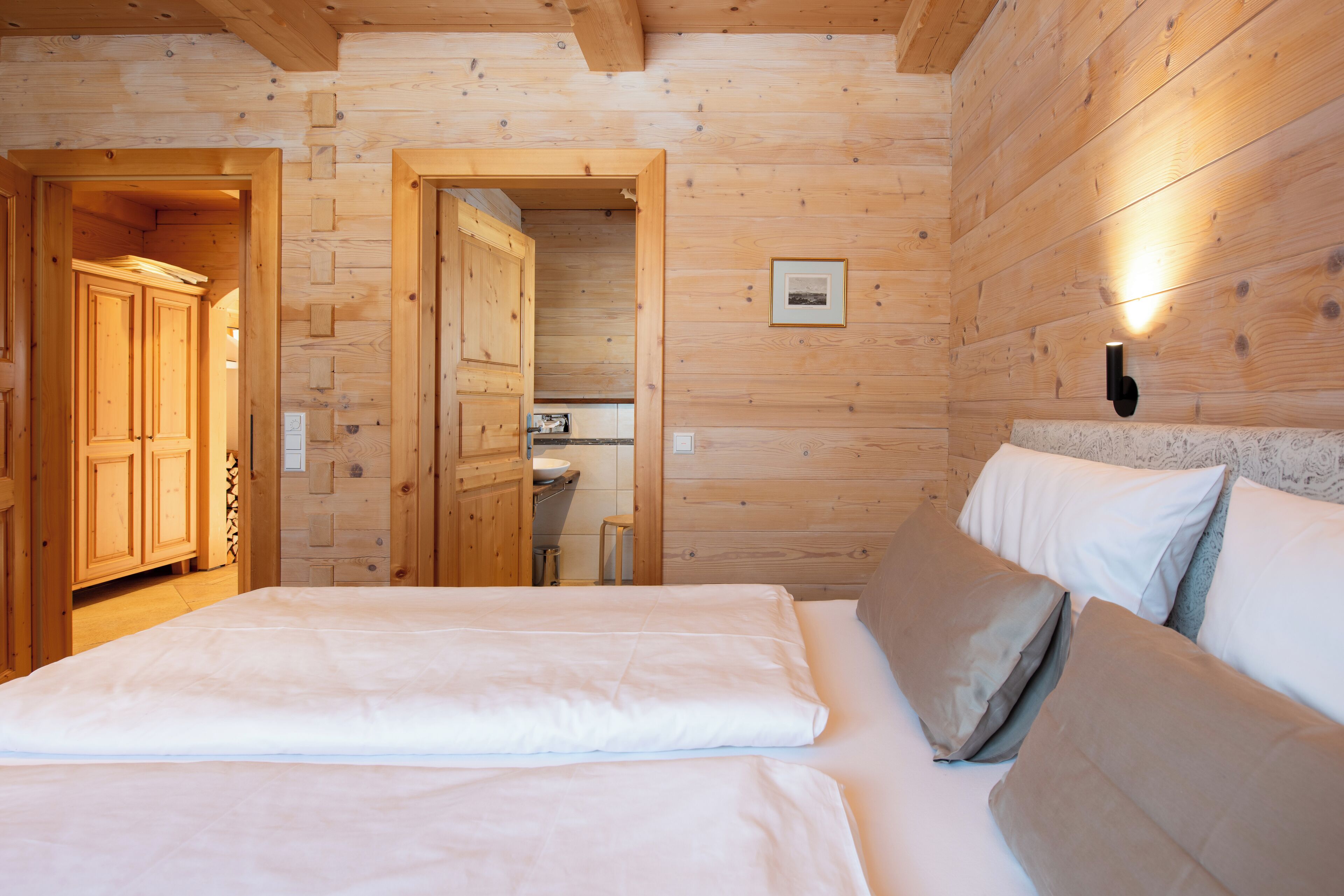 Une pièce de style cabane en bois, comprenant un lit, une armoire en bois et une petite kitchenette.
