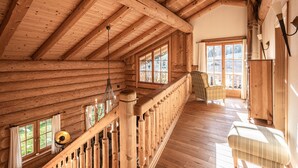 A wooden interior with a high ceiling, a staircase, and a view of the outdoors. - Chalets&Apartments beim Waicher (Ruhpolding)