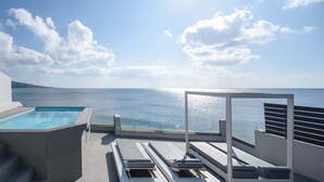 A rooftop pool area with a view of the sea, a lounge with sun loungers, and a staircase leading to the pool. - Sublime Villa & Caves (Santorini)