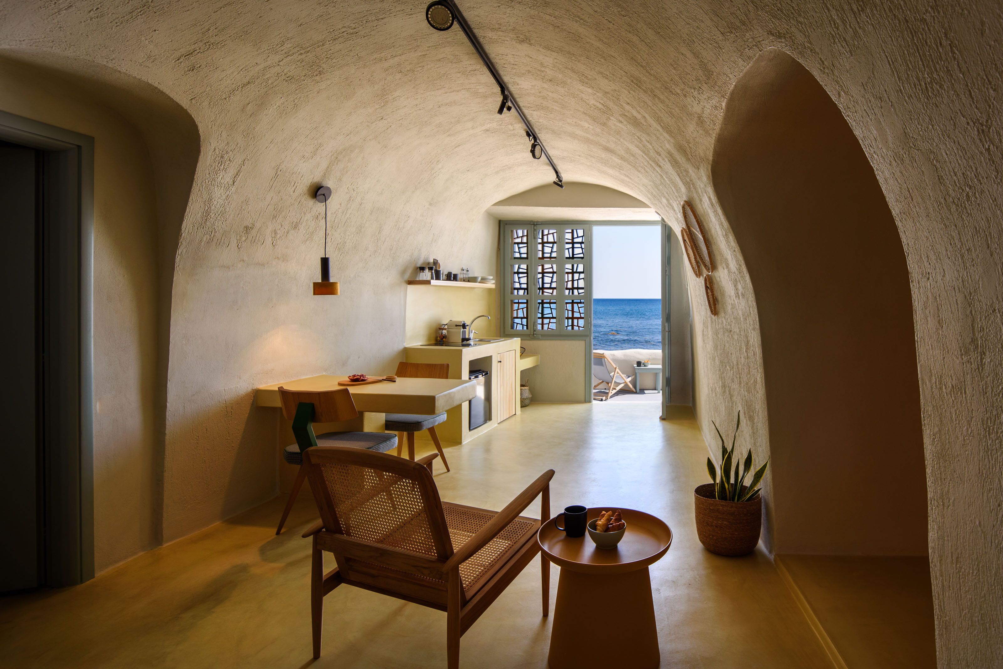 A cozy interior with a dining area, kitchen, and a view of the sea.