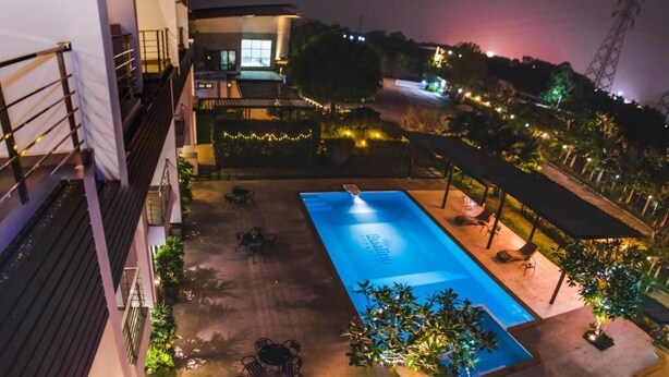 A rooftop pool area with a clear view of the pool, surrounding lounge chairs, and a covered seating area. - Bualinn Resort Nongkhai (Nong Khai)