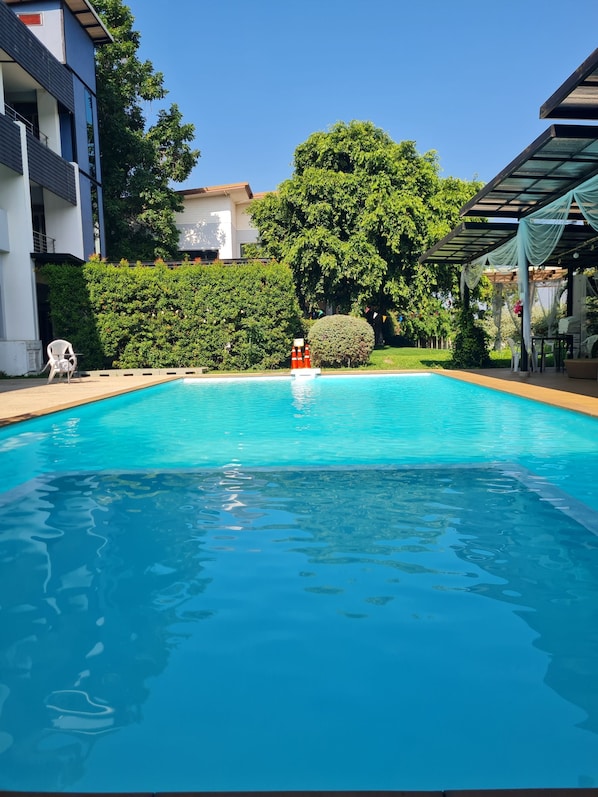 A clear blue swimming pool with a lifeguard chair and a small red lifebuoy. - Bualinn Resort Nongkhai (Nong Khai)