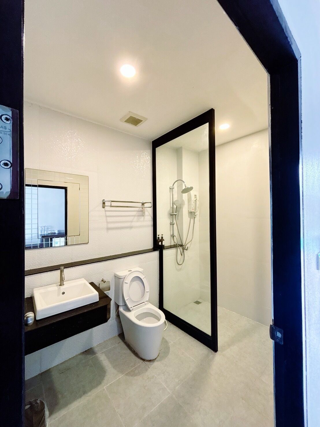 Een moderne badkamer met toilet, wastafel en douche.