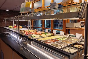 Un buffet proposant une variété de plats et une vitrine réfrigérée.