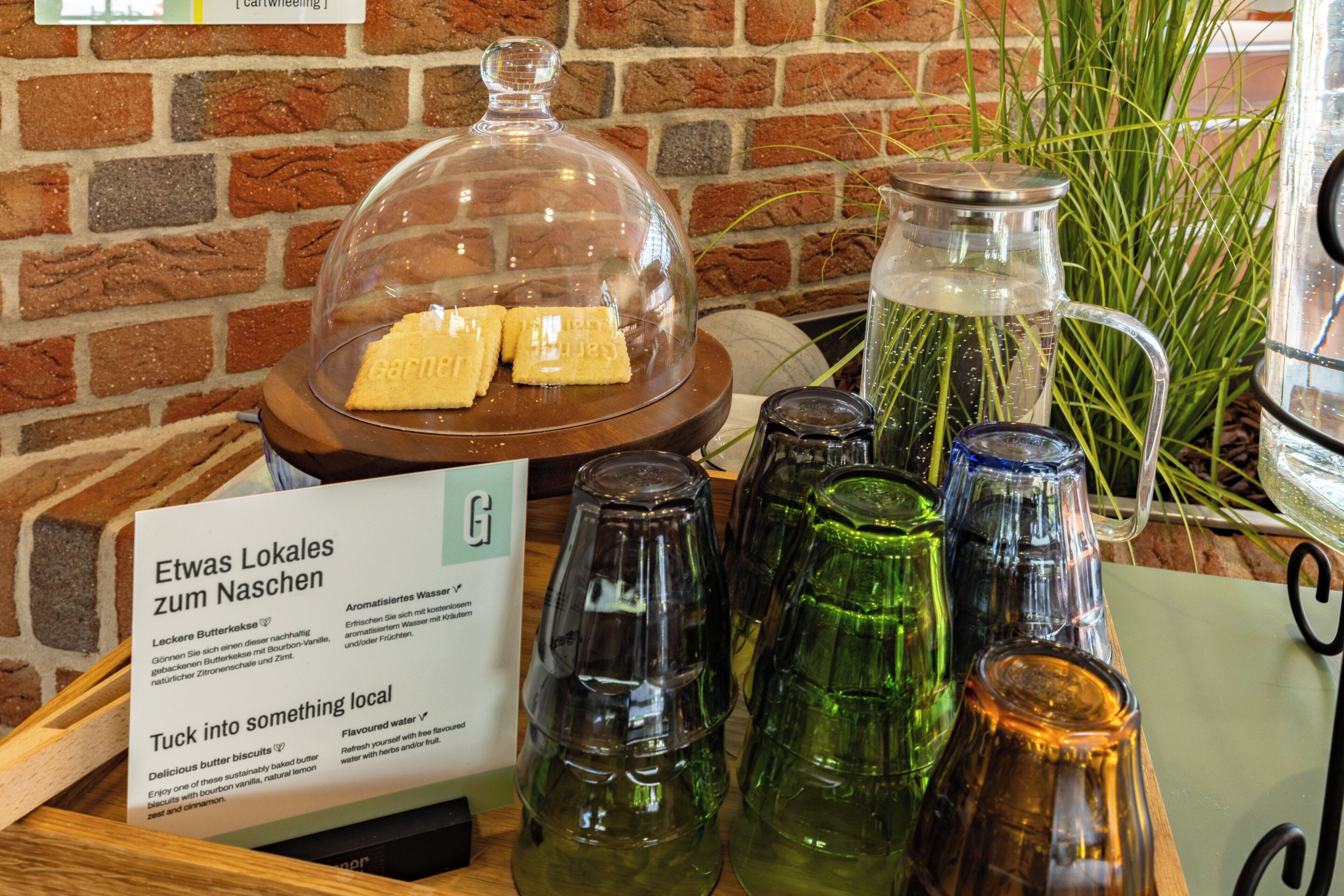 Una presentación de productos locales como snacks y bebidas, incluyendo galletas y agua saborizada, con un cartel que promociona productos de la zona.