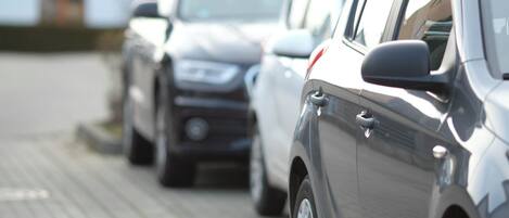 Una fila de coches aparcados sobre una superficie pavimentada.
