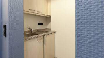 A small kitchenette with a sink, cabinets, and a countertop.