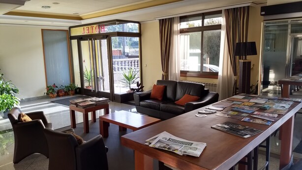 A hotel lobby with a reception desk, leather sofa, and several chairs. - Hotel Avión Vigo (Vigo)
