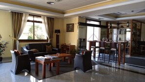 A hotel lobby with a seating area, a bar, and a view of the outside. - Hotel Avión Vigo (Vigo)