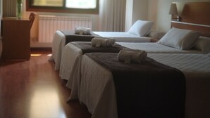 A hotel room with two beds, a desk, and a window with curtains. - Hotel Avión Vigo (Vigo)