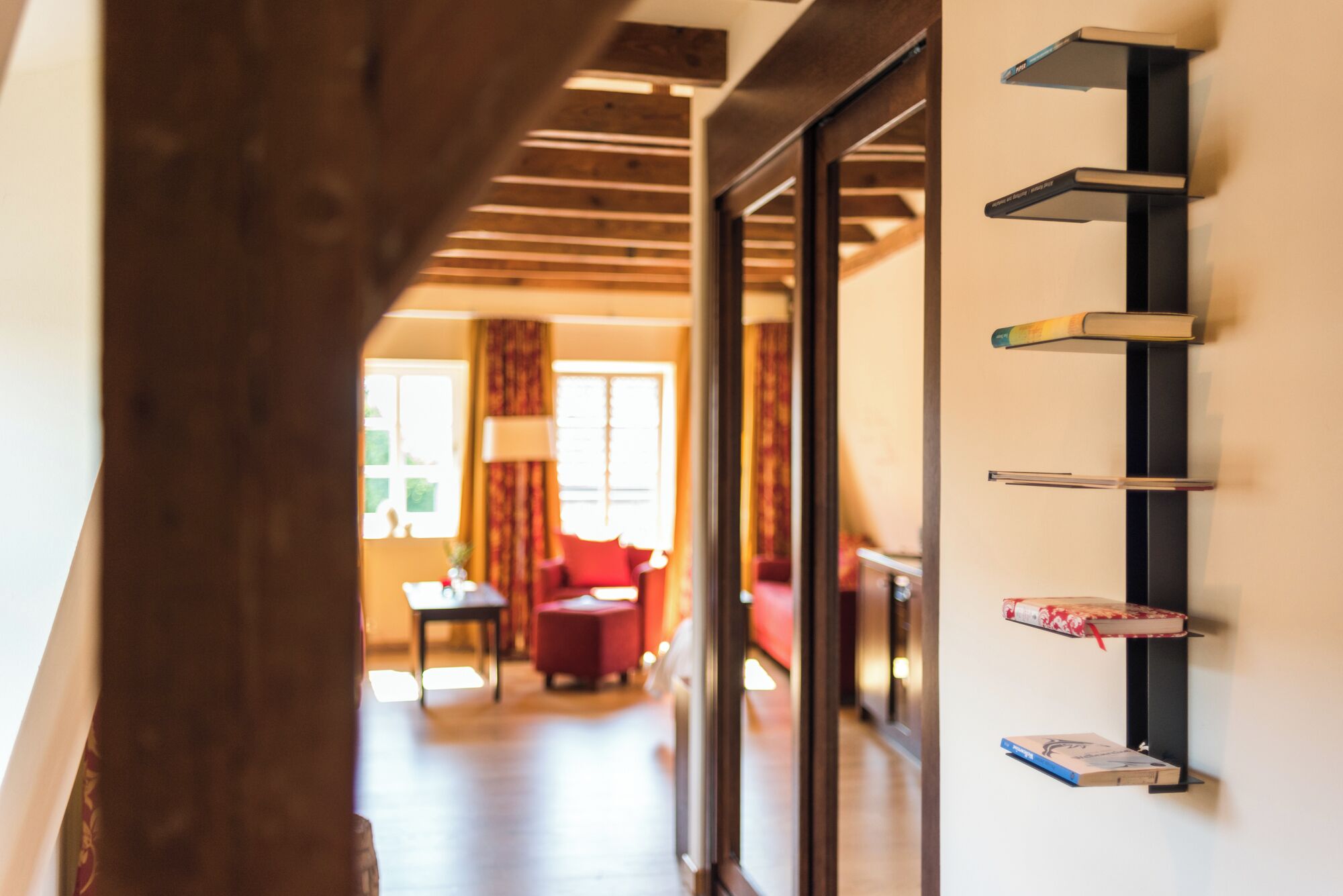 Een gang met een houten plafond en een boekenplank vol boeken.