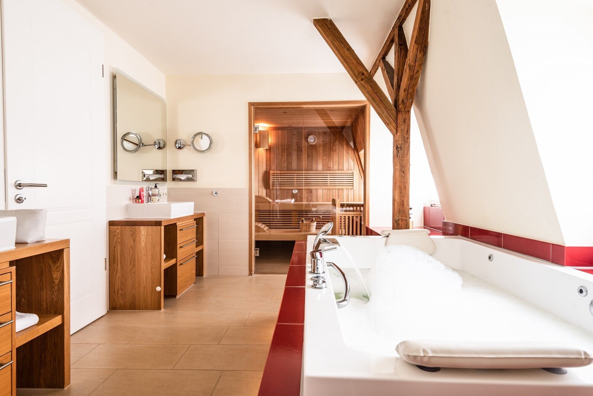 Une salle de bain moderne avec un meuble-lavabo en bois, une grande baignoire et un espace sauna.