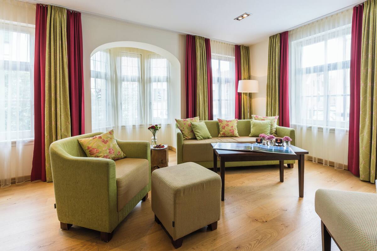 Un salon comprenant un canapé, un pouf et une table basse.