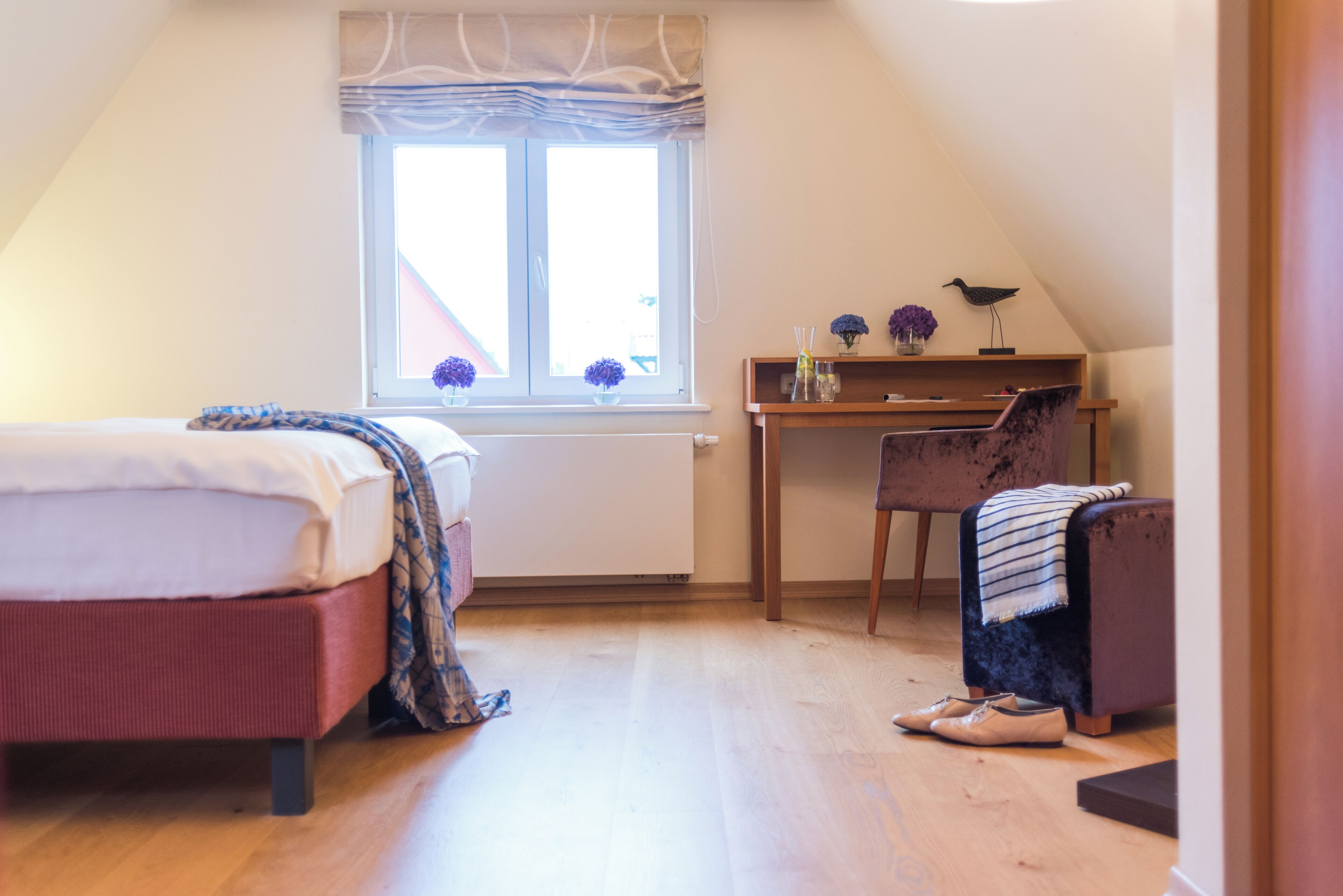 A bedroom with a bed, a desk, and a chair.