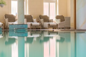 Una piscina techada, sillones reclinables de piscina