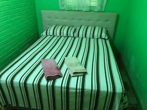Un lit avec une literie à rayures et deux serviettes pliées.