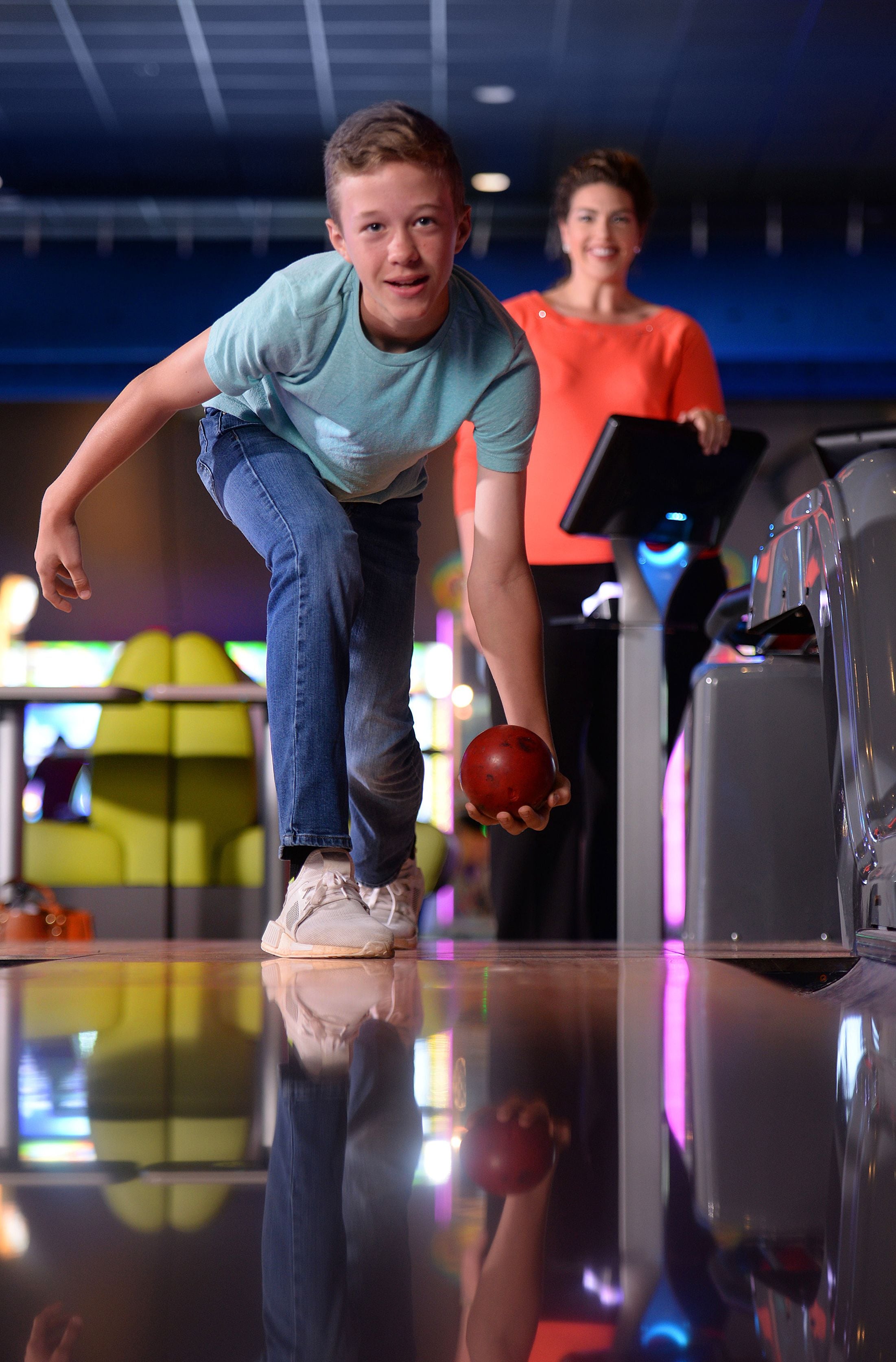 A bowling alley with a polished floor and bowling lanes.