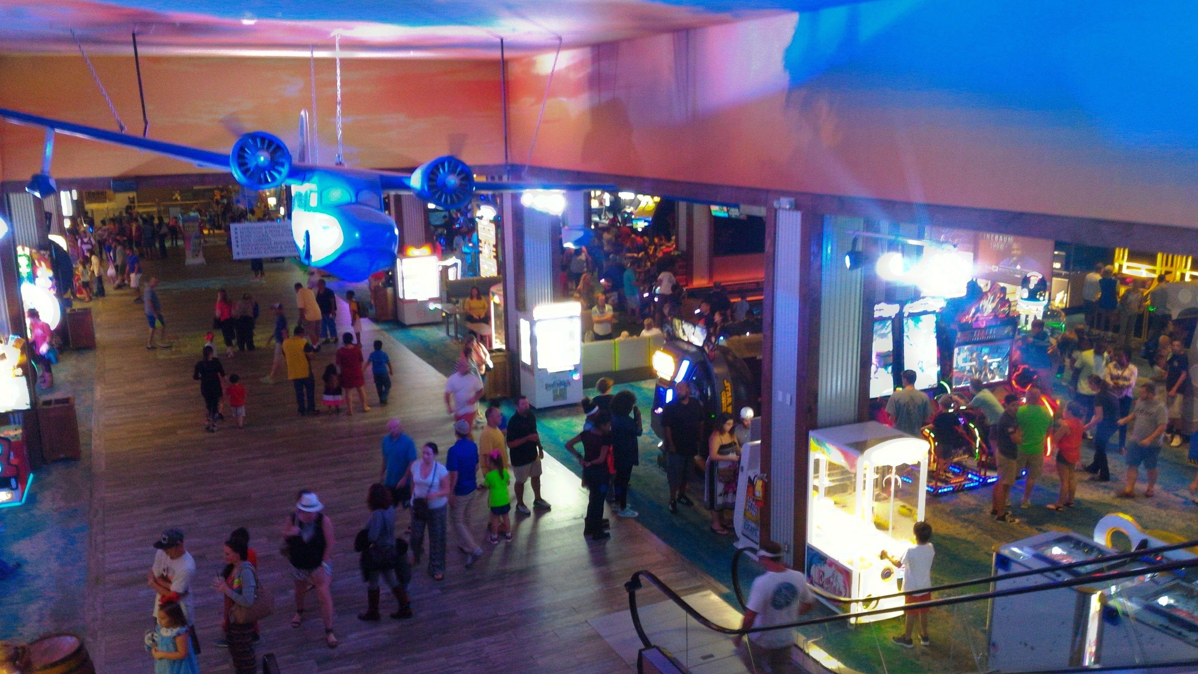 A crowded indoor space with various attractions and people.