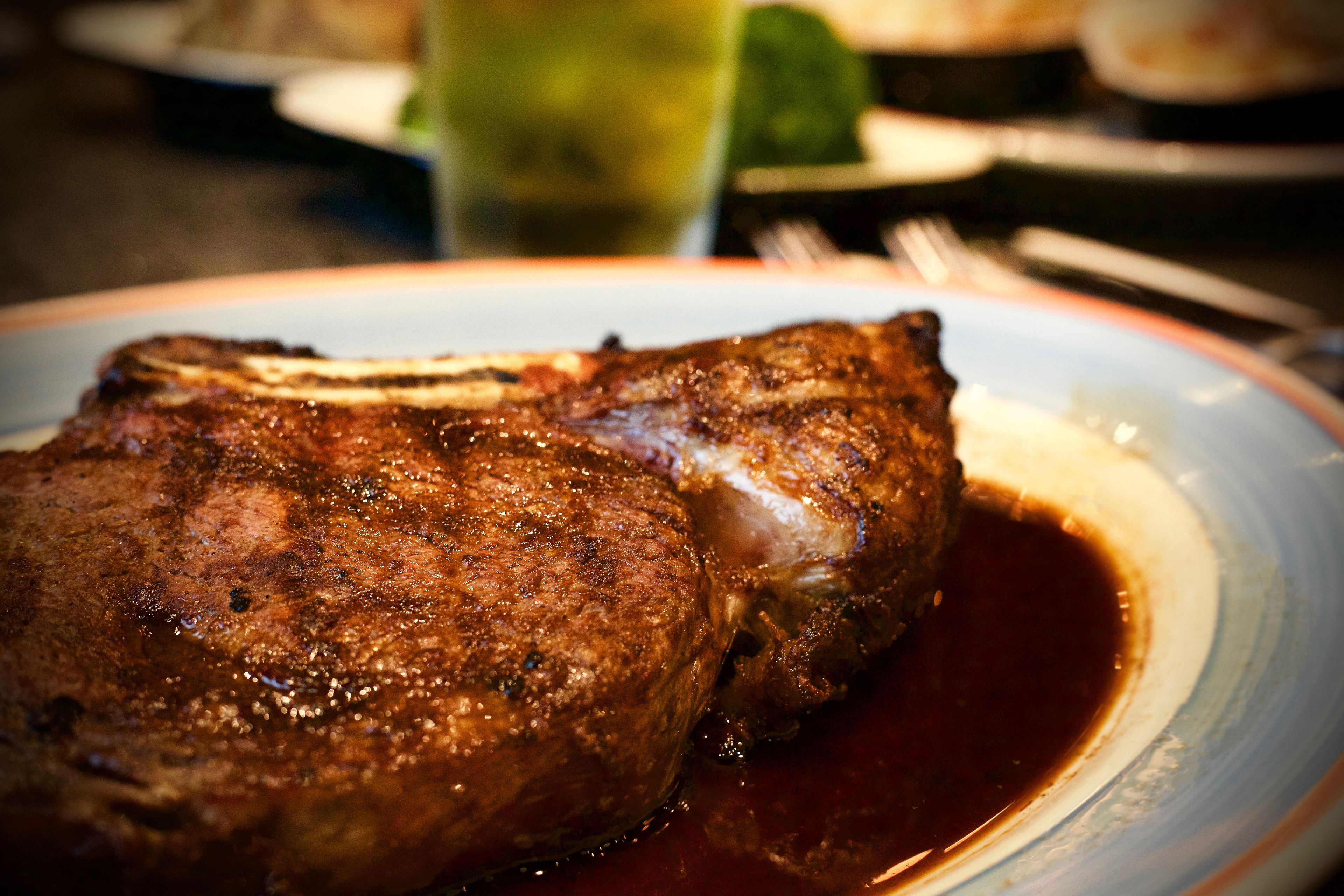 A steak with a dark sauce on a plate.