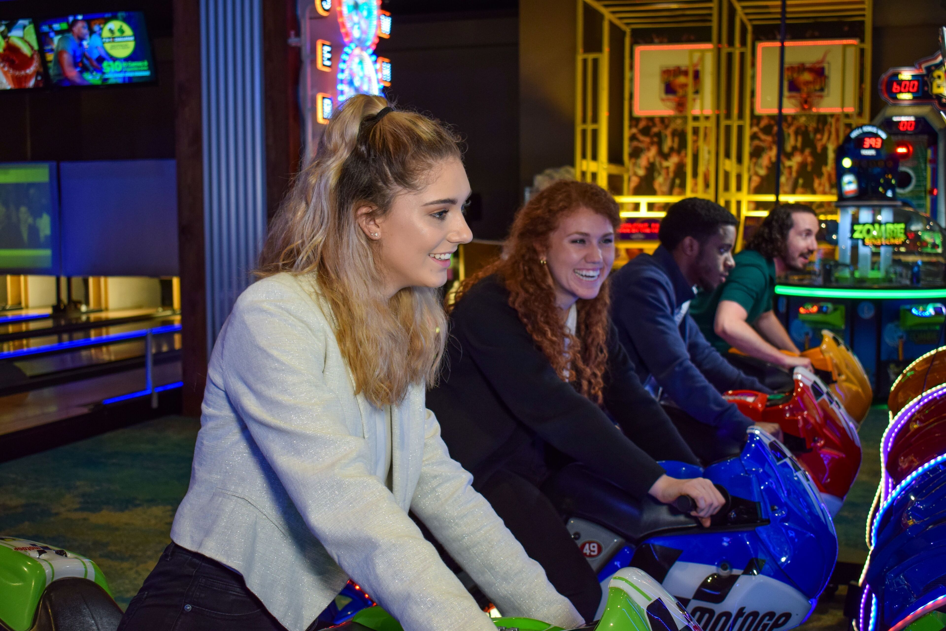 A group of people riding bumper cars in an indoor amusement area.
