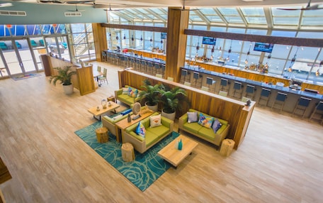 A spacious lobby with a bar area, seating arrangements, and large windows offering views.