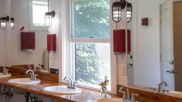 A bathroom with three sinks, wooden countertops, and a large mirror.