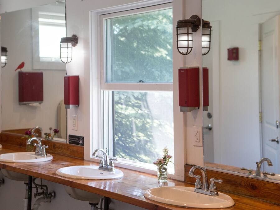 A bathroom with three sinks, wooden countertops, and a large mirror.