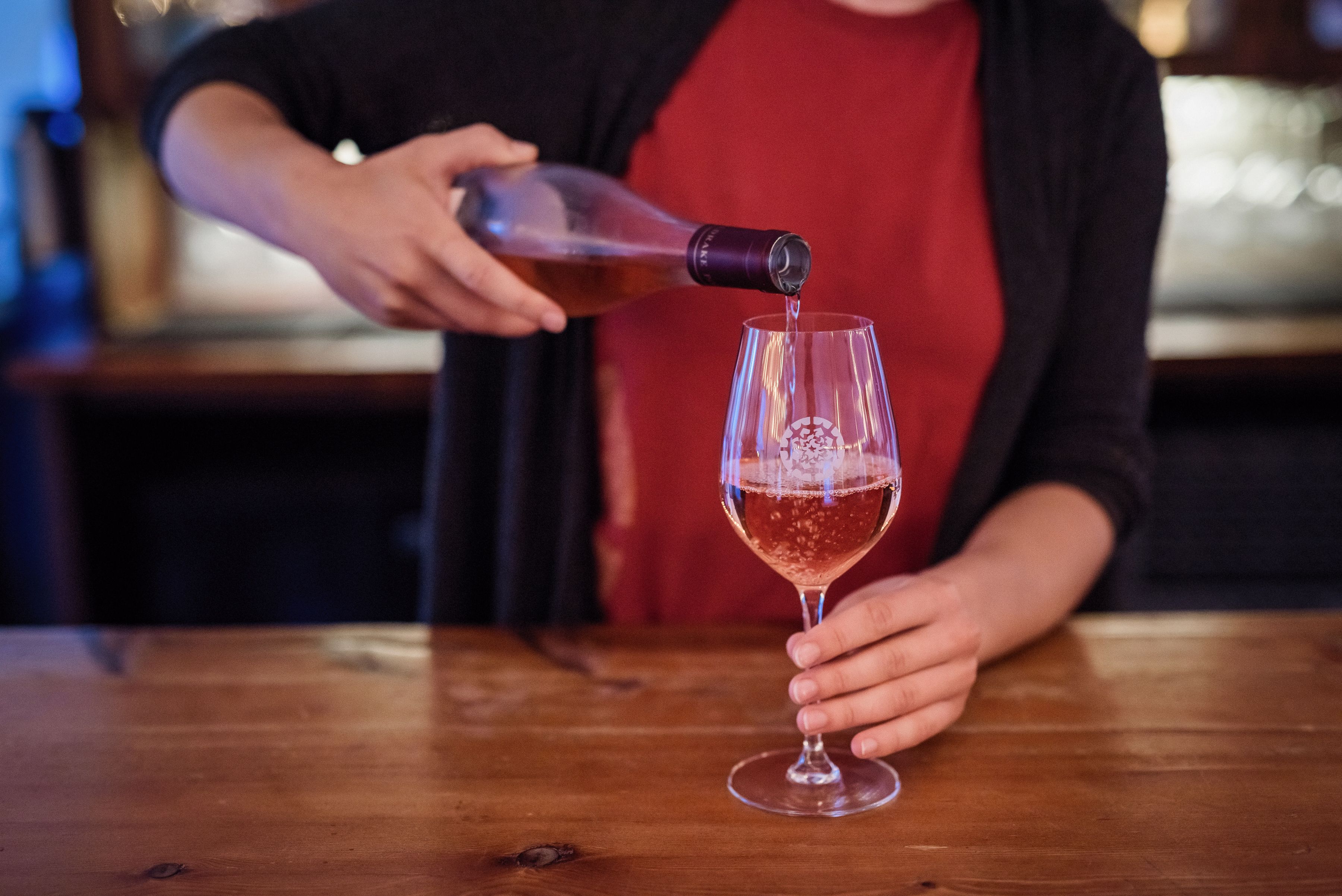 Une personne qui verse une boisson dans un verre.