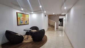 A modern interior with a curved seating area, a painting on the wall, and a staircase in the background. - Hotel Yurupary (Leticia)