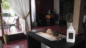 A room with a dining table, chairs, a white lantern, and a view of the outside. - Hotel Resi San Bernardo (San Bernardo del Tuyú)