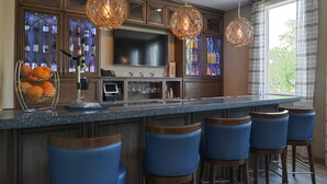 Una cocina moderna con una isla grande, taburetes de bar y un botellero.