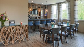 Una cocina moderna con barra, suelo de madera y taburetes azules.