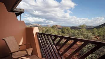 Ein Balkon mit Blick auf rote Felsformationen und einem Stuhl.