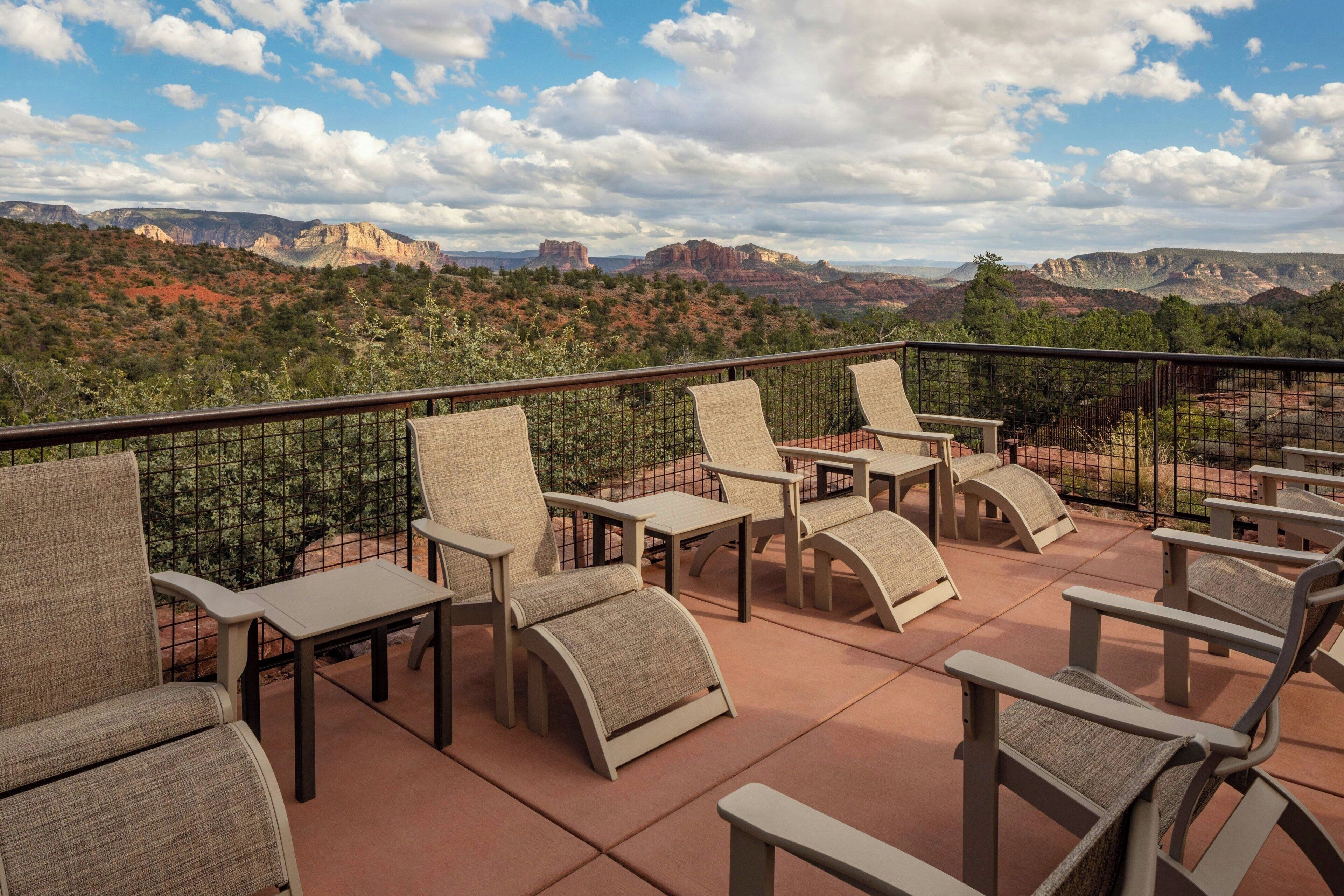 Une terrasse avec des places assises extérieures et une vue panoramique sur les montagnes.