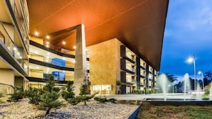 A multi-story hotel with a modern design, featuring a rooftop garden and a fountain. - Travelers Rio Verde Living Suites (Rionegro)