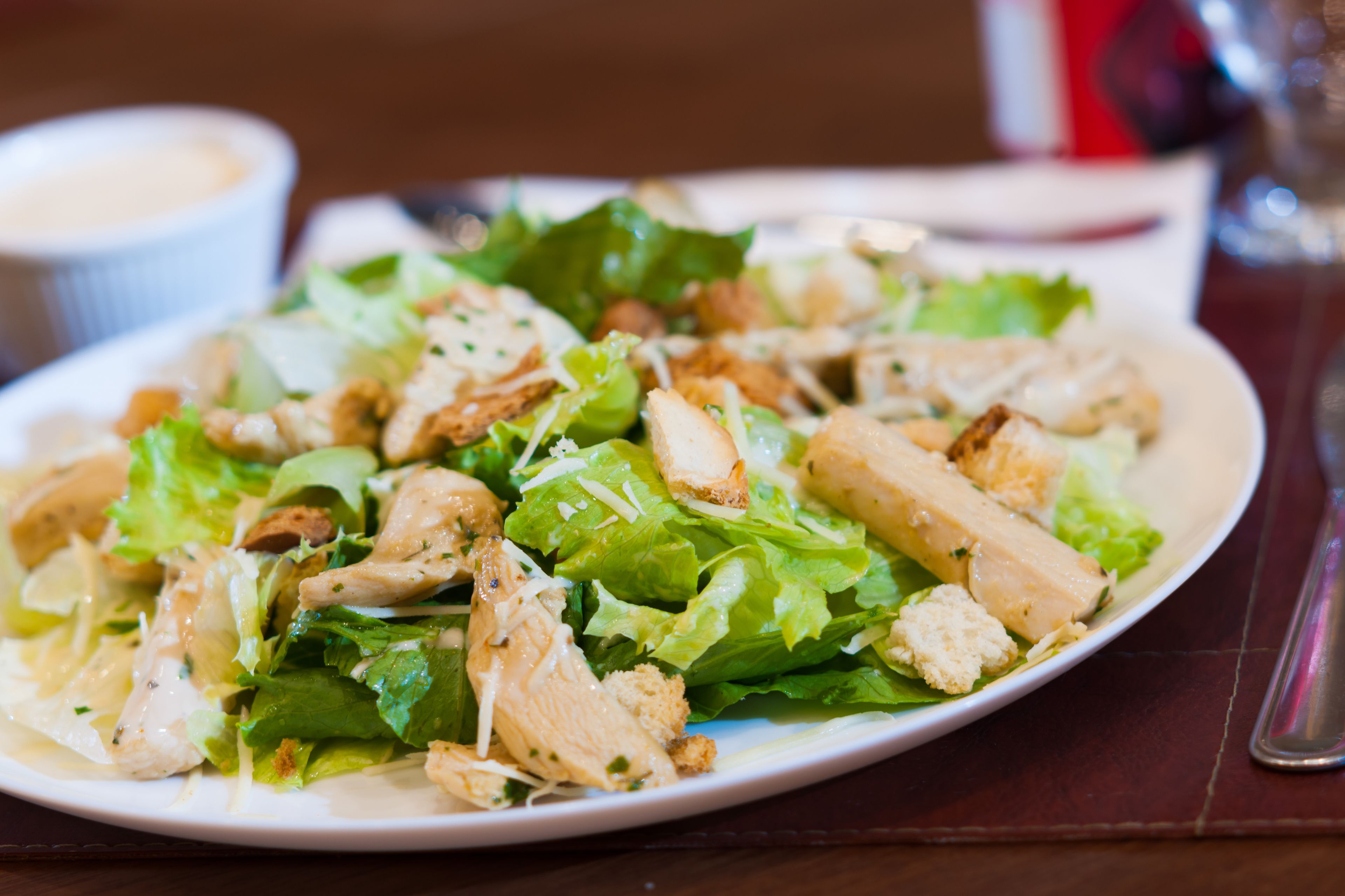 Prato de salada de frango com alface e croutons.