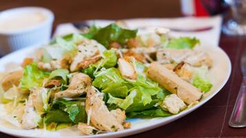 Prato de salada de frango com alface e croutons.