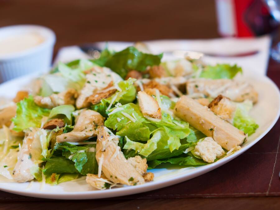 Prato de salada de frango com alface e croutons.